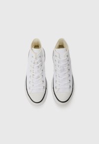 White high-top sneakers made of canvas, featuring round toes, silver eyelets, flat laces, and a black rubber sole accent.
