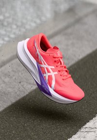 Asics-Laufschuh in leuchtendem Pink mit weißen Akzenten, ausgestattet mit einem strukturierten Obermaterial, leichtem Design und einer lila-weißen Sohle, die mit "FF Turbo" gekennzeichnet ist.