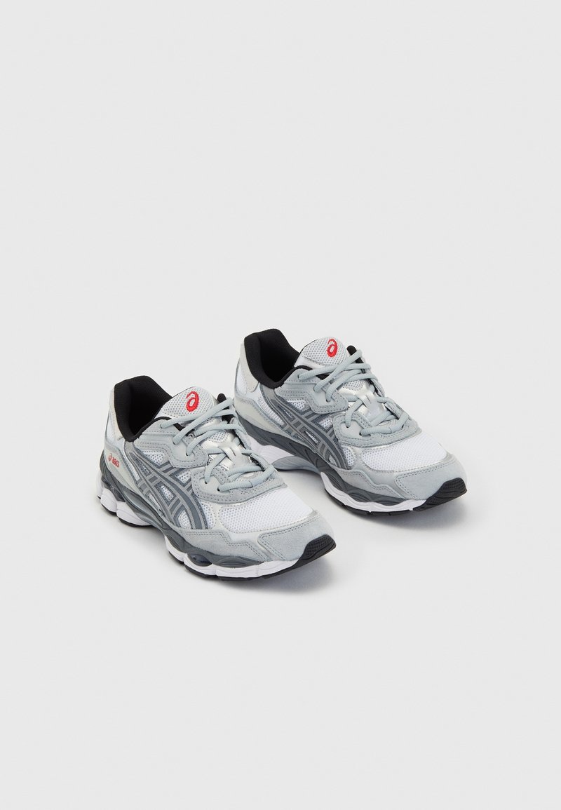 Pari harmaa ja valkoinen ASICS-juoksukengät, joissa on punainen logo, verkkomateriaali yläosassa ja pehmustetut pohjat vaalealla taustalla.
