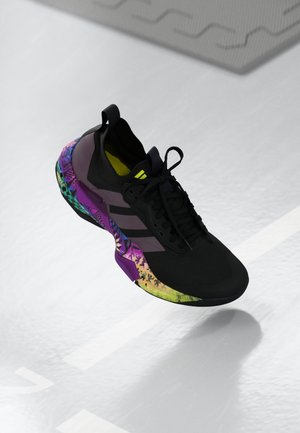 Black athletic shoe featuring a textured upper, vibrant multi-colored accents on the sole, and a prominent purple heel section.