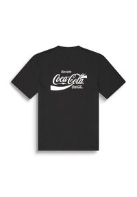 Crna kratka majica s kratkim rukavima sa bijelim logom "Bevete Coca-Cola" otisnutim na središnjem dijelu leđa.