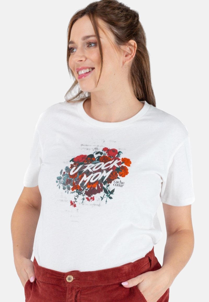 Witte katoenen t-shirt met een bloemenafbeelding en de tekst "U ROCK MOM" in vette, gestileerde letters. Korte mouwen, ronde hals.
