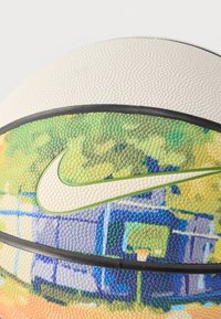 Minge de baschet Nike cu suprafață texturată și un gradient de culori verde, albastru și crem, accentuată de o bandă de cauciuc neagră și un logo.
