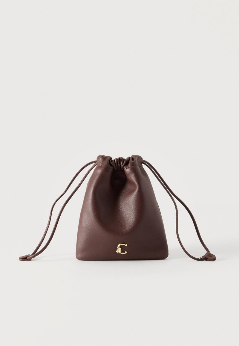 Petit sac à cordon en cuir brun avec des longues fines bretelles et un petit emblème doré en forme de lettre C au centre en bas.