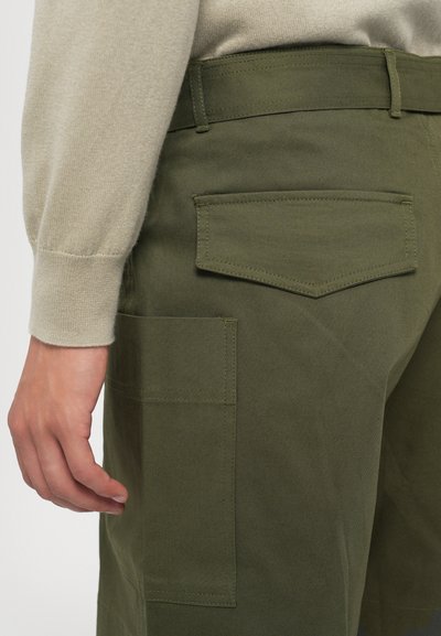 Ελαιόχρωμο cargo παντελόνι με διπλές πλευρικές τσέπες και μία πίσω τσέπη, κατασκευασμένο από ανθεκτικό ύφασμα. Διαθέτει εμφανή ραφή και επίπεδη ζώνη.