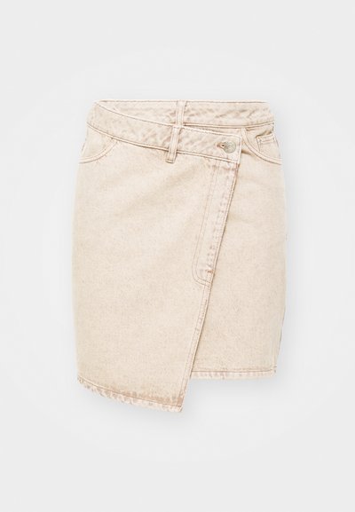 Jupe mini en denim beige au design enveloppé, dotée d'une fermeture à bouton, de coutures visibles et d'une texture légèrement usée.