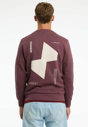 Felpa bordeaux con una grande grafica bianca sul retro, che presenta testo e una forma unica. Realizzata in tessuto testurizzato.