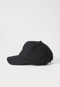 Sort baseball cap lavet af stof. Har en buet skygge og en rund krone med en knap på toppen. Side logo-tag er synligt.
