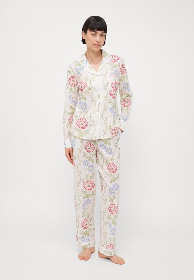 Blomster-mønstret pysjamassett i hvitt med rosa og blå blomster, laget av mykt stoff, med en knappetopp og løstsittende bukser.