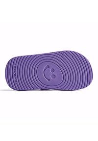 Violetti kumijalanpohja, jossa on keskeisiä uurteita ja hymyilevä kasvomuotoilu. Kokomerkinnät EUR 25 / US 8.5 sivulla.