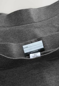 Dunkelgraues T-Shirt mit Rundhalsausschnitt und weichem Material. Das Etikett zeigt die Marke, die Größe (6 Jahre) und Pflegehinweise.
