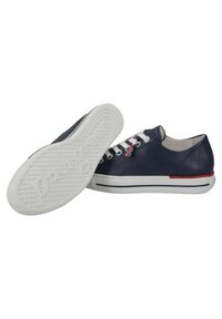 Marineblaue Ledersneaker mit weißen Gummisohlen, ausgestattet mit weißen Schnürsenkeln, roten Akzenten und einem strukturierten Profil auf der Untersohle.