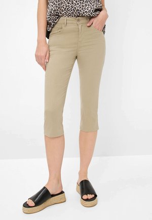 Pantalons capri kaki au design ajusté, fabriqués en coton doux. Associés à des sandales noires à plateforme tissée.