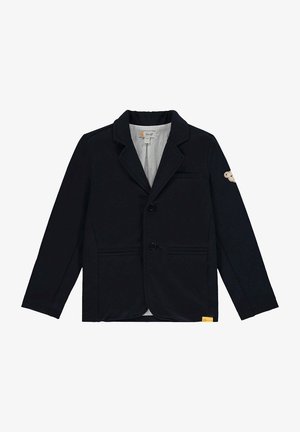 Blazer negro para niños con solapas con muesca, dos bolsillos frontales, dos botones y un pequeño parche en la manga izquierda.