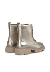 Stivali alla caviglia metallici dorati con punta arrotondata, suola chunky beige, finitura in pelle texturizzata e tre fori laterali per il laccio.