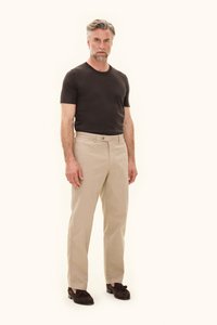 Tummanruskea lyhythihainen t-paita yhdistettynä vaalean beigeihin housuihin. Housuissa on etuosassa nappikiinnitys ja suora lahjemalli.