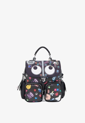 Sac à dos noir avec des yeux de dessin animé sur le rabat, des patchs colorés, deux poches avant zippées, des poches latérales et une poignée supérieure.
