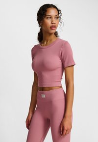 Roze geribbelde crop top met korte mouwen, gecombineerd met bijpassende high-waisted leggings. Heeft een rekbare textuur en een merklabel op de tailleband.