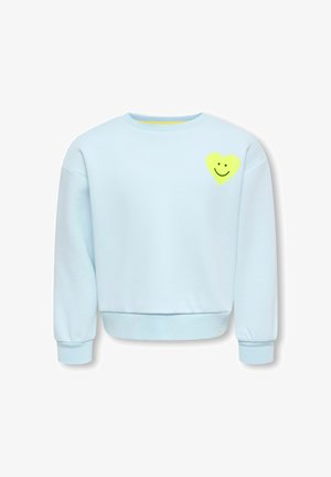 Sweat bleu clair à manches longues avec poignets et ourlet côtelés, avec un petit cœur jaune orné d’un visage souriant noir sur la poitrine gauche.