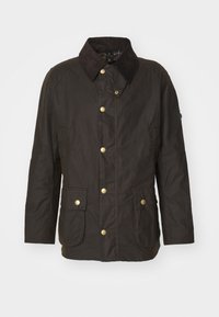 Veste en coton ciré brun foncé avec col en velours côtelé, boutons-pression à l’avant, deux poches à rabat avec boutons et manches longues.