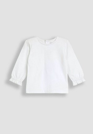 Hvid bomulds langærmet top med rund hals og samlede manchetter, der har en glat tekstur og subtile syninger.