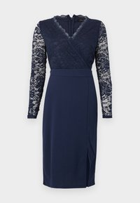 Μίντι φόρεμα σε ναυτικό μπλε με μακριά δαντελένια μανίκια, δαντελένιο κορσάζ τύπου wrap, V-λαιμόκοψη, εφαρμοστή μέση και πλαϊνή χαραγή.