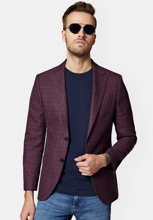 Burgundowy blazer w kratę o dopasowanym kroju, z dwoma guzikami i z wykładanym kołnierzem, noszony na granatowej koszulce z nadrukiem i zestawiony z dżinsami.