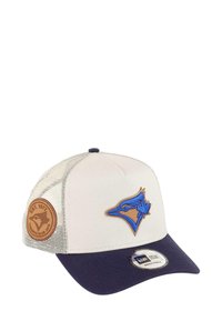 Adjustable cap featuring a cream front and navy visor. Brown leather patch on the side, blue embroidered team logo on the front. Mesh back.