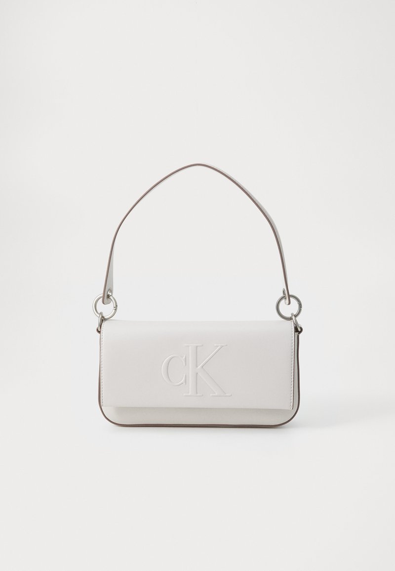 Bolso de mano de cuero blanco con logo "CK" en relieve, forma cilíndrica, diseño esbelto, ribetes oscuros en contraste y un asa superior única con herrajes plateados.