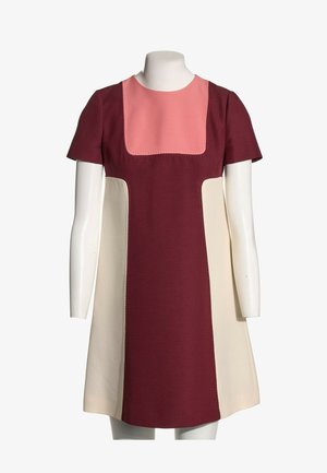 Robe courte à manches courtes, coupe trapèze, avec un centre lie de vin, des panneaux latéraux crème et un panneau d'encolure carrée rose sur un mannequin blanc.