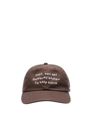 Gorra de béisbol marrón con texto bordado en blanco: "Sonríe, eres la razón por la que alguien sigue adelante."