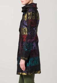 Cappotto colorato con un motivo che mescola viola, rosso, verde e oro, dotato di un colletto alto e di un tessuto texturizzato.