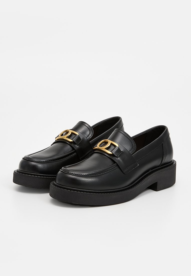 Schwarze Lederloafers mit einer dicken Plattform, die ein goldfarbenes metallisches Element am Riemen aufweisen. Glatte Textur und rundes Zehendesign.