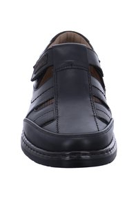 Black leather sandals with an open design, featuring vertical cutouts, a hook-and-loop strap, and contrasting stitching details.