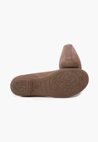 Scarpe flat in suede marrone con punta arrotondata, dotate di una suola in gomma testurizzata con motivi floreali e a forma di cuore. Dettagli di cucitura discreti.