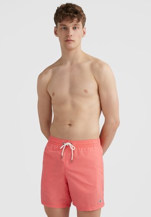 Coral swim trunks with an elastic waistband and drawstring, featuring a small logo on the lower leg and smooth, lightweight fabric.