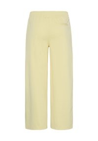 Vue arrière d’un pantalon large jaune clair avec une ceinture élastique et une poche arrière unique côté droit.