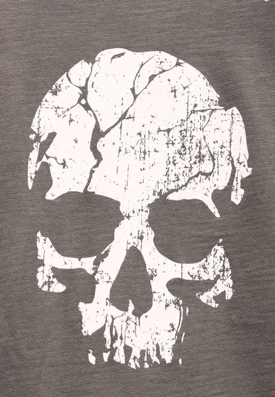 Λευκή ραγισμένη γραφική απεικόνιση κρανίου σε γκρι υφασμάτινο φόντο με υφή.