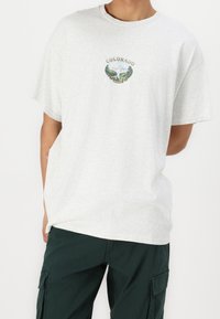 Graues Baumwoll-T-Shirt mit rundem Halsausschnitt und kurzen Ärmeln, versehen mit einem bunten "COLORADO"-Grafikdesign mit bergigem Motiv auf der Vorderseite.