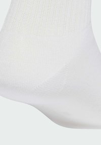 Biała bawełniana skarpetka o prążkowanej fakturze, z wzmocnionym piętą i palcami. Gładki, lekki design. Skarpetka sięga do kostki.