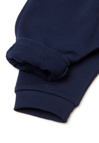 Navyblaue Baumwoll-Jogginghosen mit gerippten Säumen und glatter Textur. Der Stoff wirkt weich und langlebig, mit einem schlichten Design.