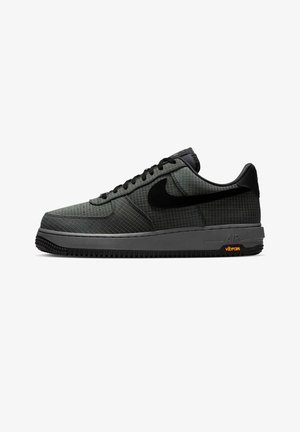 Low-Top Nike Air Force 1 Sneaker in Dunkelgrau mit schwarzem Swoosh, Obermaterial mit Rastermuster, schwarzen Schnürsenkeln und einer mit Vibram gebrandeten Sohle.