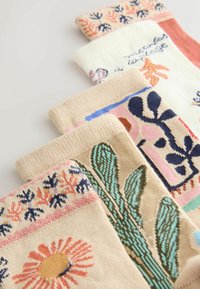 Sada piatich párov ponožiek v rôznych pastelových farbách. Obsahuje kvetinové a botanické vzory, jemnú pletenú textúru a kontrastné lemy.