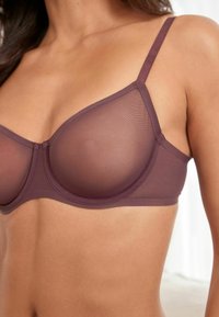 Mauve podprsenka s kosticemi a jemnými košíčky, nastavitelnými ramínky a hladkým povrchem. Obsahuje klasický design s minimalistickým stylem.