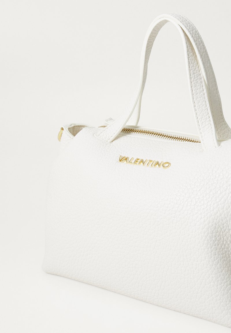Bolso de mano de cuero texturizado blanco con una cremallera dorada y la marca "Valentino" en dorado. Dos asas superiores para llevar. Forma compacta.