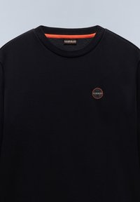 Czarny sweter z okrągłym dekoltem i pomarańczowym wykończeniem wewnętrznym. Ma małe okrągłe logo na klatce piersiowej. Miękka faktura, casualowy design.