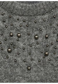 Grauer Strickpullover mit Zopfmuster, der über das Gewebe verstreute runde Verzierungen und einen gerippten Kragen aufweist.