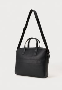 Black leather bag with two top handles, a detachable shoulder strap, and a front pocket. Smooth texture and rectangular shape.