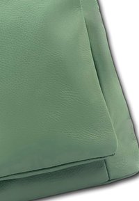 Groene leren tas met een gladde textuur, rechthoekige vorm en gevouwen ontwerp. Zichtbare stiksels accentueren de randen.