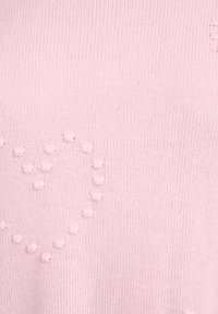 Svetloružový pletený sveter s textúrovaným vzorom srdca vytvoreného z vypuklých bodiek po celej látke. Mäkká, hladká textúra.